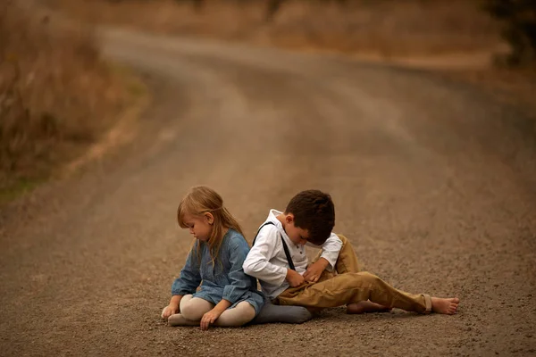Irmão e irmã estão brincando na estrada — Fotografia de Stock