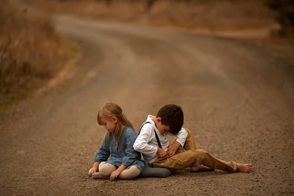 Hermano y hermana están jugando en el camino —  Fotos de Stock