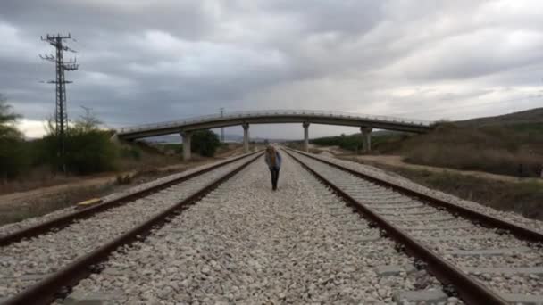 Уставшая молодая женщина едет на встречу по рельсам — стоковое видео