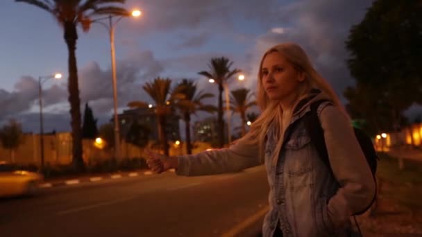 一个女人旅行者, 在路上走了一夜。疲惫的年轻女子背包客, 开始在阳光明媚的乡村道路上的旅程. — 图库视频影像