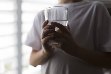 bir bardak su tutan çocuk yakın çekim