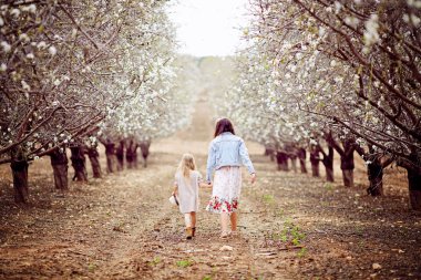 İki küçük kız birbirlerine tutan eller ve çalışan tarafından orman yolu günbatımında iletmek