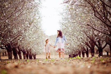 İki küçük kız kardeş beyaz birbirlerine elele ve parkta açık havada dans giymiş