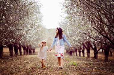 iki küçük gülümseyen sarışın kız elbiseler içinde duran ve alanını sarılma ve bir kız onu oyuncak kurt onun elinde tutan