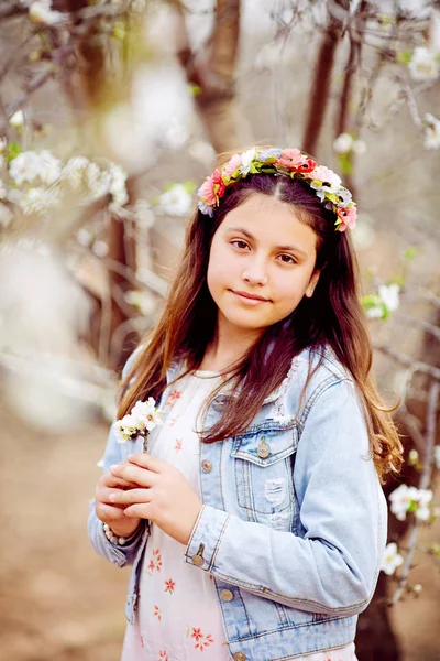 Retrato de mulher jovem no campo florido no tempo de primavera. Flores de amêndoa florescem. Menina vestindo vestido branco e chapéu de sol rosa — Fotografia de Stock