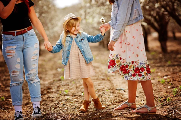 Ältere Schwestern halten ihre jüngere schöne Schwester mit Down-Syndrom fest an der Hand — Stockfoto