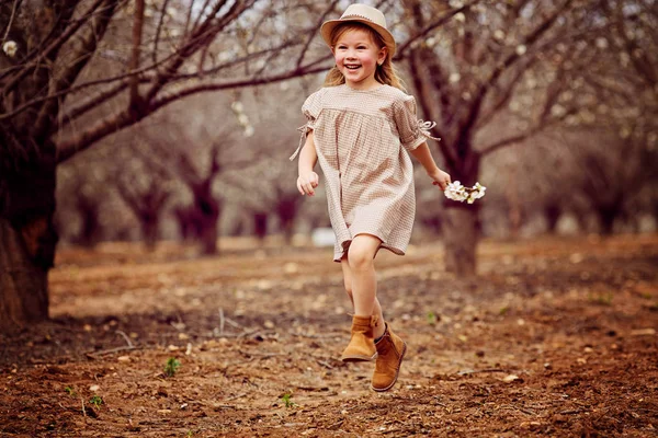 Petite fille souriante courant sur un chemin dans le parc — Photo