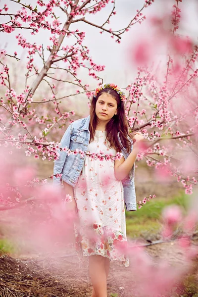 Mladá dívka v květinové zahradě v jarním období — Stock fotografie