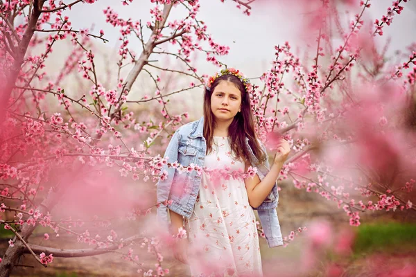 Jong meisje in de bloementuin in de de lentetijd - Stock beeld — Stockfoto
