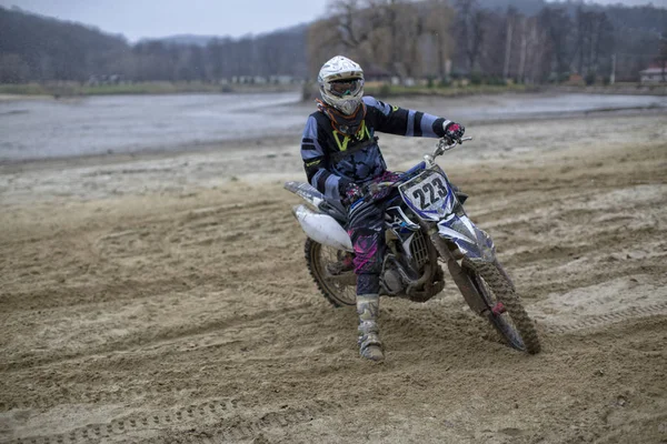 Unbekannter Mann mit Helm und Ausrüstung fährt Motorrad im Sand — Stockfoto