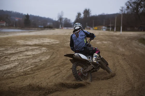 Motocross-Profi auf dem fmx-Motorrad steht auf der Sanddüne und übersieht das ganze extreme Gelände, das er heute befahren wird. — Stockfoto