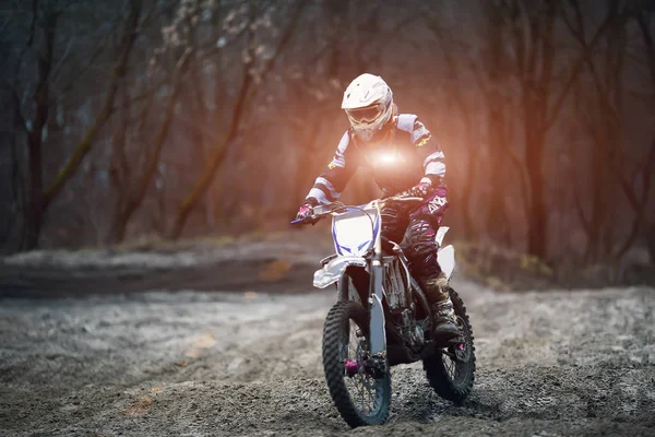 Asiento de hombre en la motocicleta en la carretera forestal durante el amanecer . —  Fotos de Stock