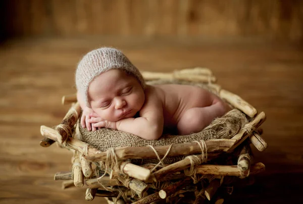 Bonito bebé recién nacido con una pequeña gorra de lino en la cabeza está durmiendo en una cesta —  Fotos de Stock