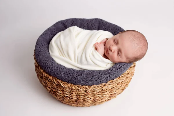 新生児の木製バスケットで眠っている女の子。新生児の写真. — ストック写真
