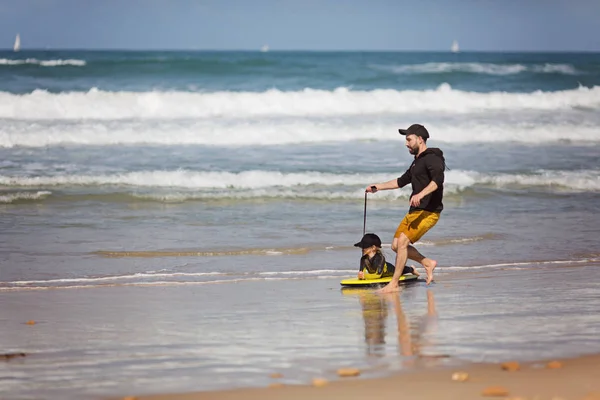 Vater und Tochter spielen tagsüber am Strand. Konzept der freundlichen Familie. — Stockfoto
