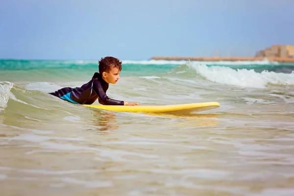 Парень покоряет волны на доске для серфинга — стоковое фото