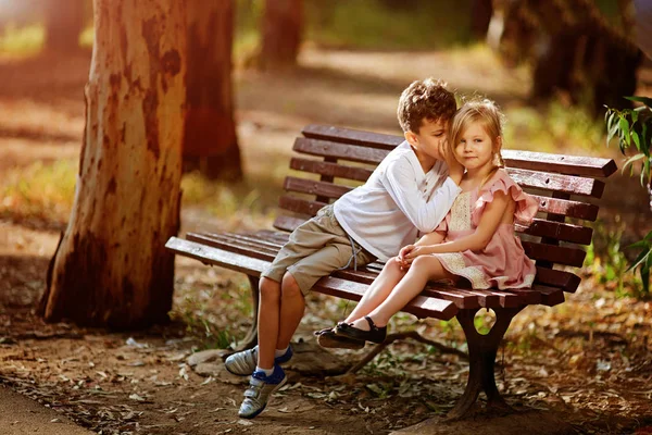 Un chico lindo comparte un secreto con su hermana menor . —  Fotos de Stock