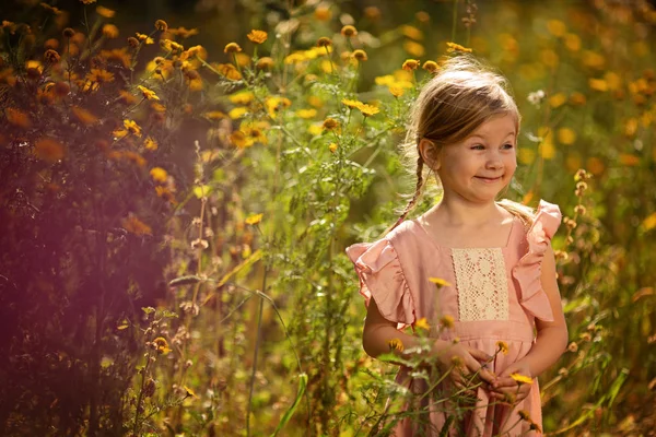 Dziewczyna, różowy sukienka, żółte kwiaty — Zdjęcie stockowe