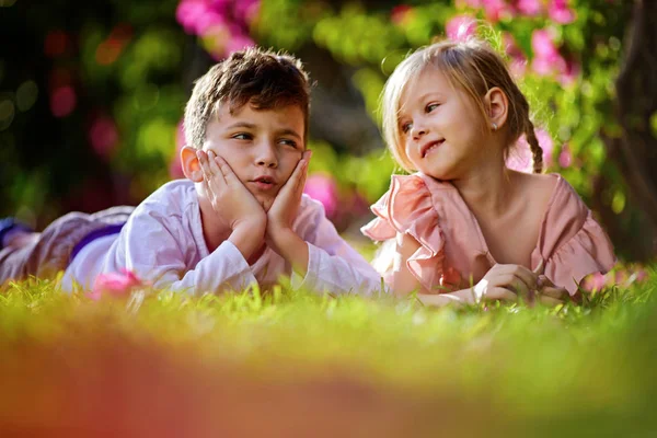 Хлопчик і дівчинка відпочивають на зеленій траві влітку — стокове фото