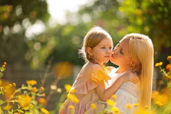 Família feliz em um prado de verão. menina criança bebê filha abraçando e beijando mãe — Fotografia de Stock