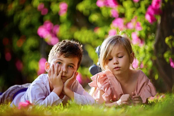 Zwei träumende Kinder liegen im Gras — Stockfoto