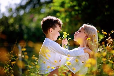 Doğada yürüyüş sırasında şirin küçük oğlunu taşıyan genç anne