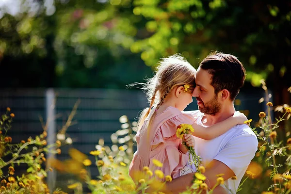 Niña en brazos de padre. Hombre besando a su hija en su mejilla. Familia y amor . — Foto de Stock