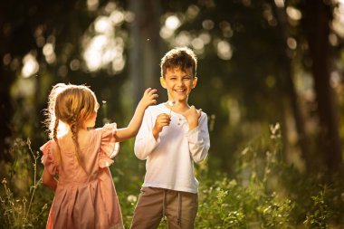 Mutlu kız ve erkek kardeş parkta birlikte.