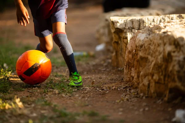 Futebol na grama com a família em pé ao ar livre no parque. Pernas de menino prestes a jogar futebol com seus pais no jardim — Fotografia de Stock