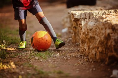 Kumsalda futbol oynayan çocuk