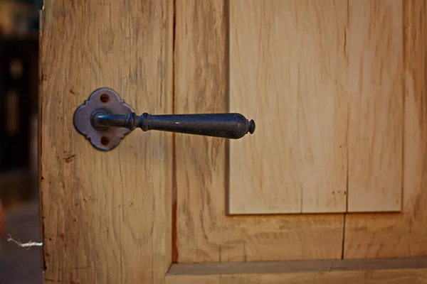 Slightly opened wooden door with latch handle closeup — Stock Photo, Image