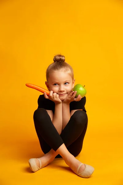 पिवळ्या पार्श्वभूमीवर एक सफरचंद, गाजर आणि क्रीडा मुलगी. आहार आणि निरोगी खाण्याची संकल्पना — स्टॉक फोटो, इमेज