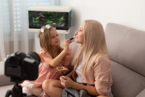 年轻的美丽博客作者和她可爱的女儿在家里录制视频 — 图库照片