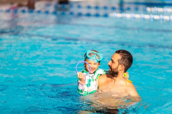 Papa apprend à une petite fille à nager dans la piscine — Photo