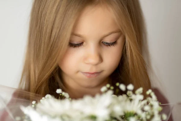 一个漂亮的少女手持一束白花的近照 — 图库照片