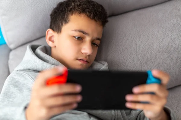 Jongen speelt videospelletjes op een draagbare console — Stockfoto