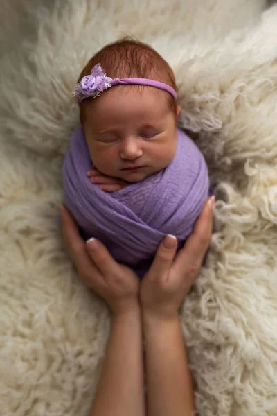 El concepto de seguridad y felicidad. Recién nacido niña está durmiendo en una pose de capullo en sus brazos madres —  Fotos de Stock