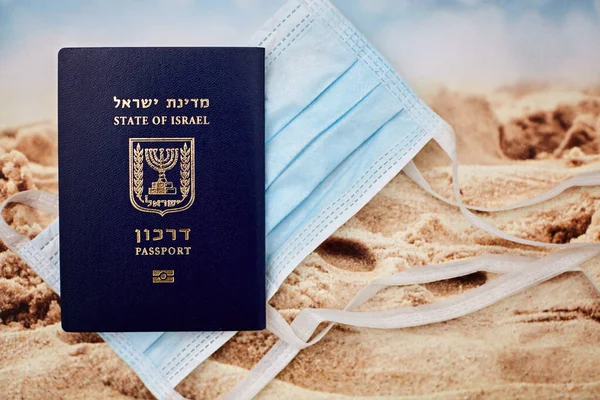 Coronavirus and travel concept. Note COVID-19 coronavirus, passport and mask. Coronavirus outbreak, epidemic in Israel. Travel restrictions and quarantine of tourists infected with Coronavirus.