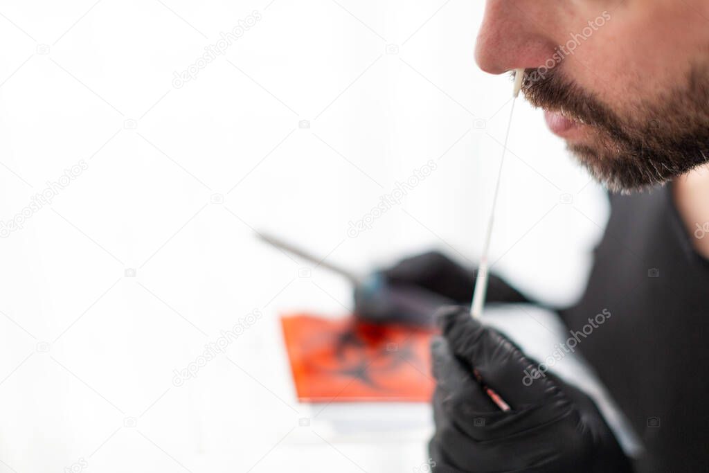 Man makes with a cotton swab a nasal swab test
