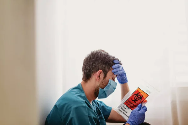 Tired doctor with a biological package of medical test — Stock Photo, Image