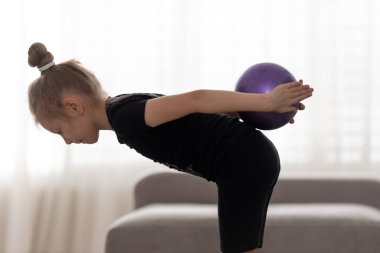 Topla akrobatik egzersiz yapan esnek, küçük kız çocuk jimnastikçisi. Spor, eğitim, fitness, aktif yaşam tarzı konsepti