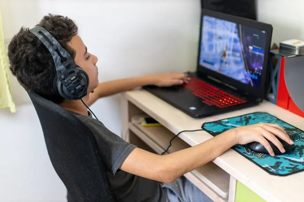 Mały chłopiec gracz zależny gra na laptopie w domu — Zdjęcie stockowe