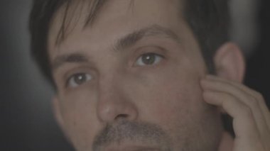 Genç çekici adam tıraş olmadan önce cildini kontrol eder. nötr renk