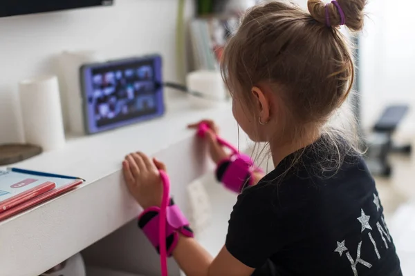 Прелестная девушка в очках смотрит онлайн-видео на ноутбуке и занимается фитнесом дома — стоковое фото