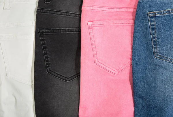 Denim kot kumaşı. Çok renkli kot pantolon arka planı. Pembe, gri, siyah ve mavi renkler. — Stok fotoğraf