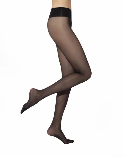 Piernas de mujer joven caucásica en medias de nylon negro sobre fondo blanco — Foto de Stock