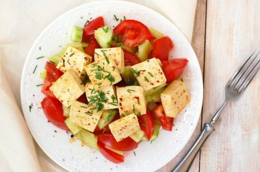 Sağlıklı vegan salata sebze, domates, salatalık, yeşil biber, soya peyniri, chives ve zeytinyağı üzerinden