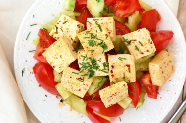 Sağlıklı vegan salata sebze, domates, salatalık, yeşil biber, soya peyniri, chives ve zeytinyağı üzerinden