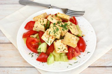 Sağlıklı vegan salata sebze, domates, salatalık, yeşil biber, soya peyniri, chives ve zeytinyağı üzerinden