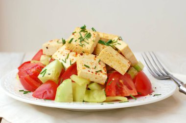 Sağlıklı vegan salata sebze, domates, salatalık, yeşil biber, soya peyniri, chives ve zeytinyağı üzerinden